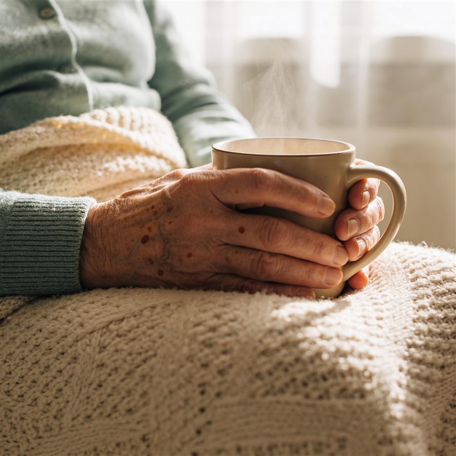 Older hands cradling a warm mug